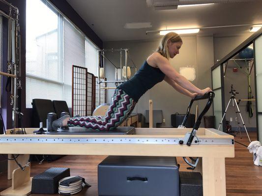 Vanessa stretching on a Balanced Body Pilates reformer.