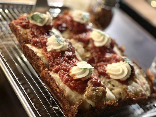 Margherita pizza with whipped ricotta, basil, and flavorful tomato sauce. Crispy crust. Added sausage to this. Decadent.