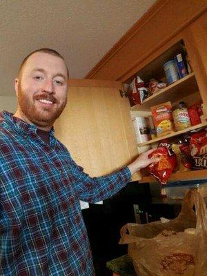 Daniel R. putting groceries away for his client