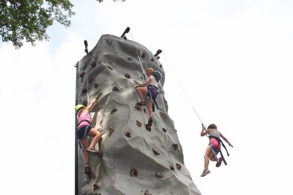 Challenges await on the rock wall! Campers climb four skill levels to ring the bell at the top.