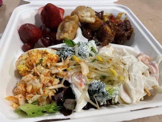 Deviled egg, mandu, kimchi, crab meat salad, orange chicken, and fruit