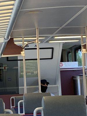 Staff not covering nose with scarf after scolding a pregnant woman for putting her feat being on a seat on an empty train.