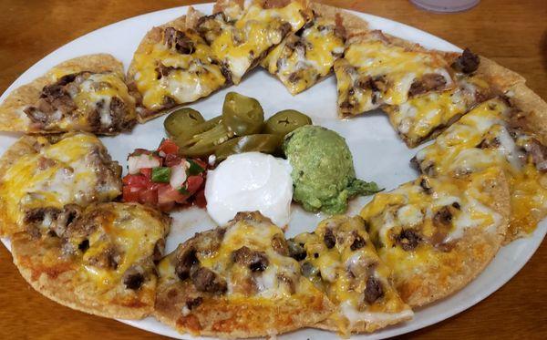 Grande Fajita Nachos with steak (Mexican-style, $15). Comes with sour cream, pico de gallo, and scoop of guacamole