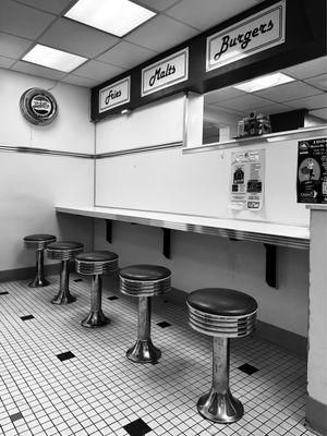 Classic diner stools at the bar with a retro Pepsi clock.