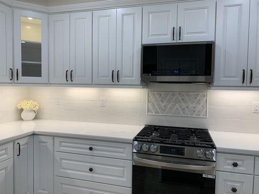 New lighting, contrasting backsplash tiles and burnt bronze knobs add just the right touch!