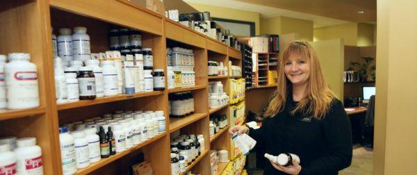 Patient Care Coordinator Caryn with the many supplements offered at Oregon Regenerative Medicine