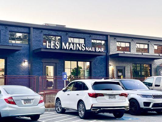 A picture of the front of Les Mains from the parking lot. Parking is free at The Works.