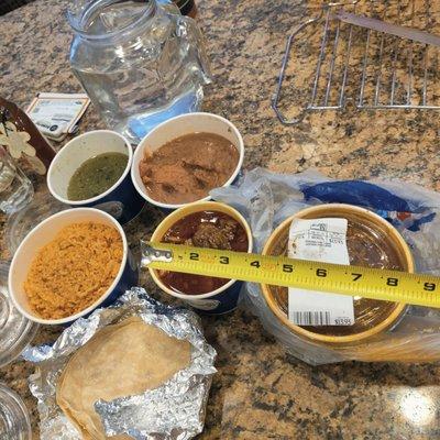 Family meal (rice beans, meat entree, green salsa- small serving?) on left and large meat ala carte on right.