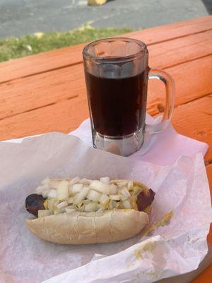 Polish dog with mustard and onions and a frosty mug of root beer.