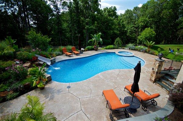 Mountain lake or free form pool with cantilevered concrete decking and coping.