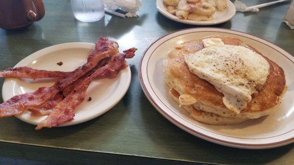 Pancakes with bacon and an egg over easy. They serve with real butter and real maple syrup.