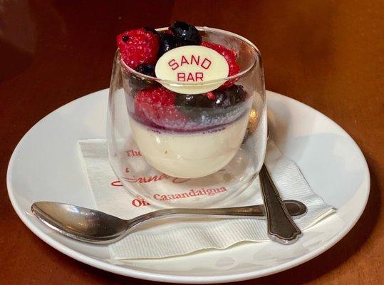 Panacota with fresh blueberries, raspberries and blackberries topped with a white chocolate candy.