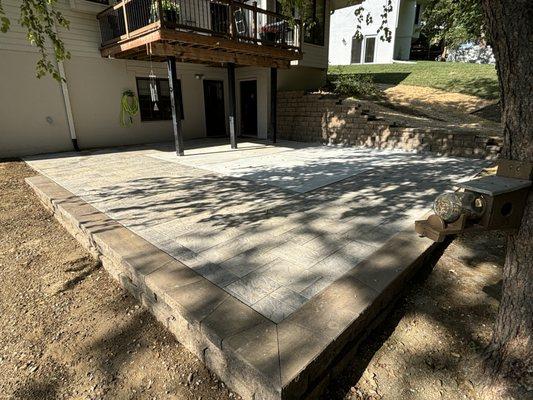 Paver patio/concrete with uplifting retaining wall.