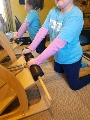 Cup and Release - Child Performing Pilates Chair Exercise