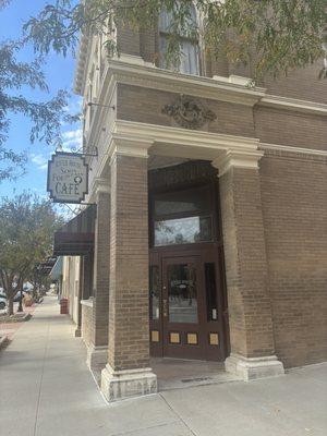 Front entrance of restaurant including original businesses logo over the archway.