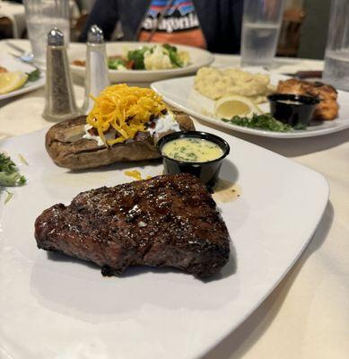 Sirloin steak with butter garlic sauce and baked potato with butter, sour cream, cheese and bacon