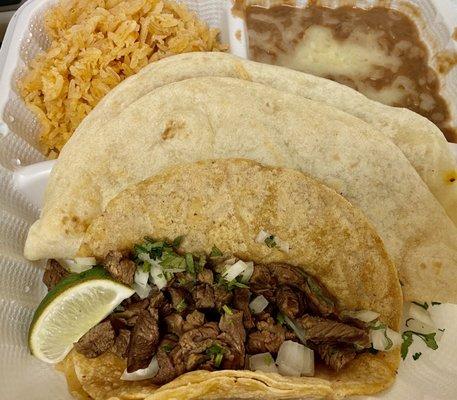 Carne asada crispy taco, chicken taco (hiding behind crispy taco), beans with cheese and rice