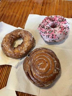 Sour cream cake donut, frosted strawberry donut and coffee roll