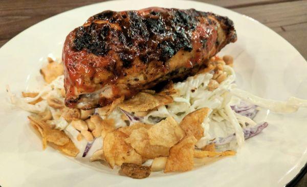 Grilled chicken on cabbage and crushed potato chips.