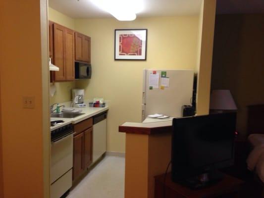 Kitchen with a small stove dishwasher and a big fridge, toaster and microwave.