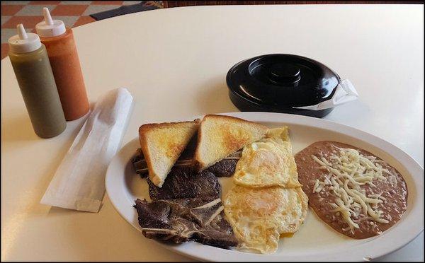 Long shot of my "Huevos Fuegos" breakfast, showing the main plate, the tortillas and the red and green sauce.