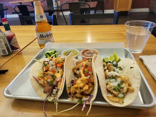 A trio of tacos from right to left: whitefish,  shrimp, and chicken