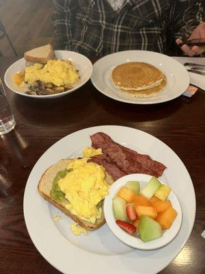 The big breakfast bowl with sourdough toast, avocado toast with turkey bacon on the side, for extra, and pancakes.