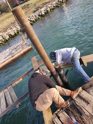 Welding on pipe extension to existing dock pipe to raise the dock.