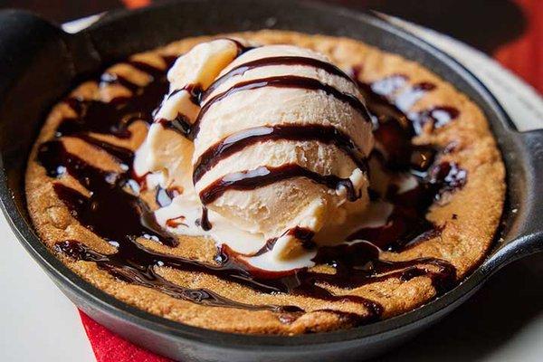 Skillet cookie with vanilla ice cream and chocolate sauce.