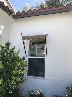 Custom awning with weatherproof fabric and custom brown scalloped trim.