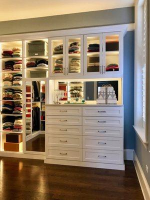 White lighted Master Closet with mirrored and fluted glass doors.