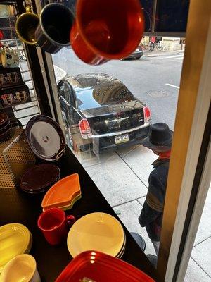 The car after driving backwards on the sidewalk, hitting James, and damaging the side of our business.