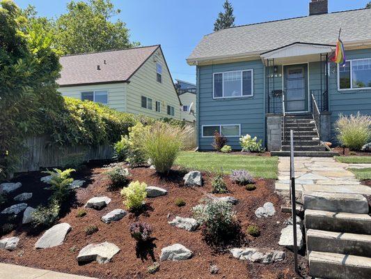 Plantings, new sod, rock retaining. Includes irrigation.