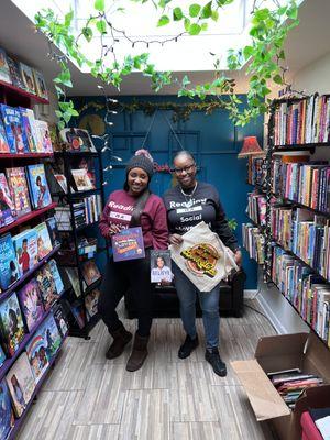 Owners taking picture inside of store highlighting Independent Bookstore Day materials