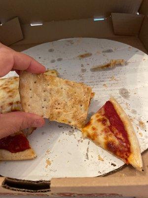 The pizza dough that is not fresh. Note the little holes from the manufacturing process. This tastes like a giant export soda cracker.