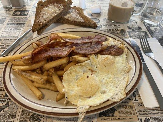 Two eggs over medium with bacon, wheat toast and French fries instead of home fries.