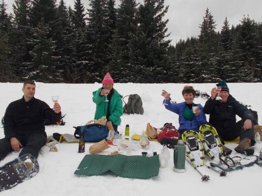 Clients enjoying a glass of wine while snowshoeing up near Mt. Hood