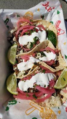 Steak tacos with picked onions, queso and cilantro lime crema with a side of limes. $3.00 each and soooo worth it