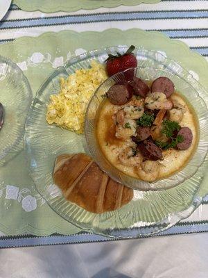 Shrimp and grits, soft scrambled eggs and croissant.