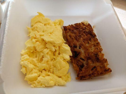 Complimentary breakfast. Shown: two scrambled eggs and hash browns