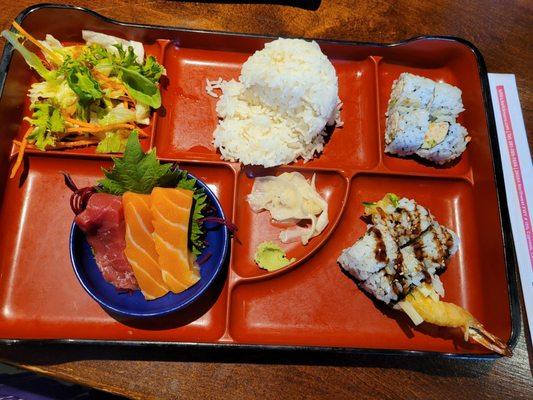 Bento box with tempura  roll and sashimi.