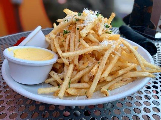 Truffle Fries - shoe string potatoes tossed with truffle infused oil, fin herbs, Pecorino-Romano & house-made aioli dip