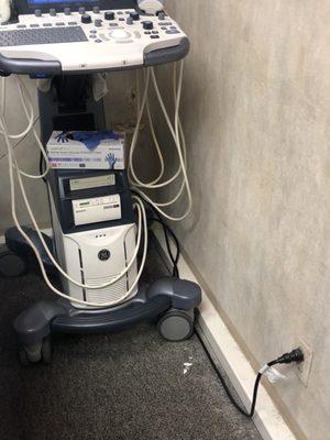 Further distance away from pile of dirt in biopsy procedure room next to ultrasound machine