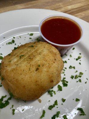 Large rice ball (Meat, fresh mozzarella and green peas) served with tomato sauce