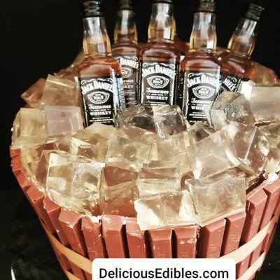 Custom Jack Daniels theme cake on ice with kit-kat bars around the cake. Best of all cake was made of tres leches with organic strawberries