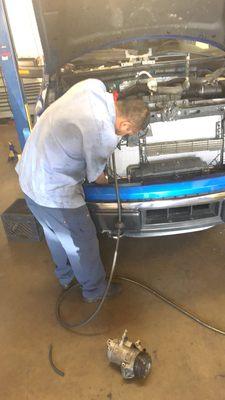 One of the technicians replacing the air conditioning condenser.