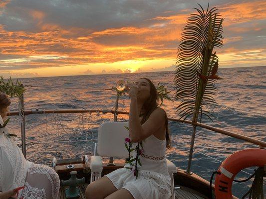 My friend enjoying some champagne while the sun sets behind her