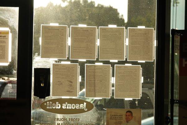 Sunlight pours through the entryway glass, posted with Dallas County COVID legal notices during The Era of The Pestilence.