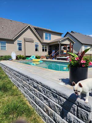 Retaining wall wrapped around an inground swimming pool in a sloped back yard in Clarksville Tn.