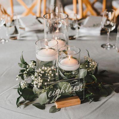 Glass cylinder vases with floating candles centerpieces.